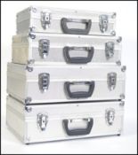 A stack of 4 20th century aluminium aircraft style / camera cases luggage sets all of graduating
