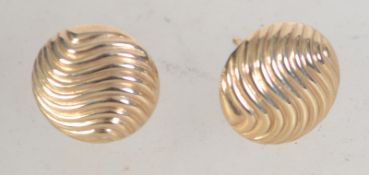 A pair of 9ct gold button stud earrings with wave decoration. Weight 1g.