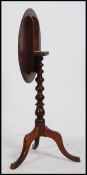A Victorian mahogany tripod wine table raised on splayed legs with bobbin turned column and
