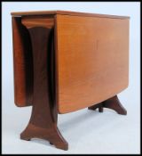 A 1970's teak wood Danish influenced G-Plan drop leaf dining table raised on shaped supports with