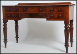 A Victorian 19th century mahogany writing table desk raised on fluted baluster legs with central