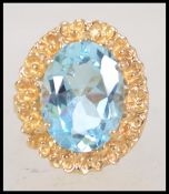 An 18ct gold Italian ring set with a large oval cup topaz in a stylized flower setting. Size R.