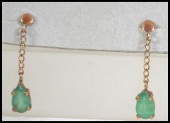 A pair of 9ct gold and green stone drop earrings. Measures approx 1 inch drop. Weight 1g.