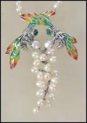 A ladies freshwater pearl necklace having silver pendant of large form adorned with insects having