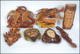 A collection of hand carved and painted wooden wall plaques to include Green Man, merchant man,