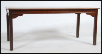 A 20th century flame mahogany coffee table of rectangular form raised on square legs with with