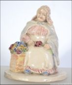 An early 20th century figure of a lady flower seller.