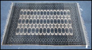 An early 20th century Bokhara rug having 3 rows of 15 medallions to the centre with geometric