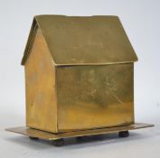 A trench art money box in the form of a house being raised on 4 pad feet with screw lid to