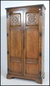 An early 20th century solid oak wardrobe having qtr panel fielded full length doors with English