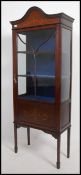 An Edwardian mahogany stencil inlaid display cabinet bookcase being raised on squared legs with