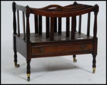 A Regency style mahogany canterbury - magazine rack being raised on turned legs with castors,