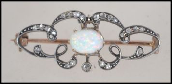 A Victorian Art Nouveau 9ct gold and silver diamond and opal brooch having an articulating pendant.