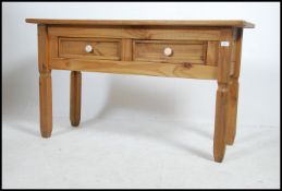 A 20th century contemporary pine side - console hall table being raised on squared legs with