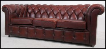 An antique style oxblood red leather Chesterfield sofa settee having buttoned back leather scrolled