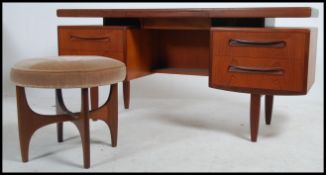 A G-Plan teak wood writing table desk having suspension set pedestals of drawers and top all raised