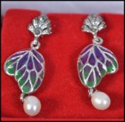 A pair of ladies silver and plique a jour earrings with adorned freshwater pearl drops.