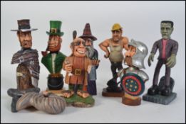 A collection of 9 hand carved and painted wooden figurines to include a Frankenstein, Road Worker,