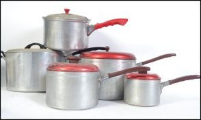 A set of 3 vintage mid century aluminium and red lid saucepans together with a similar pair of