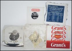 A collection of five novelty resin paperweights to include Grants Whisky, Conoco Oil,