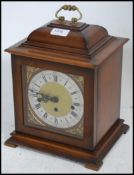 An antique style English bracket clock with brass spandrels and silvered chaper ring with roman