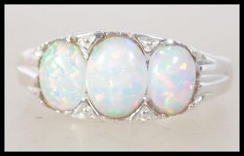 A ladies silver and opal 3 stone ring having ribbed shoulder to the shank. Total weight 3.