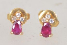 A pair of 18ct gold ruby and diamond earrings with teardrop ruby surmounted by three diamonds.
