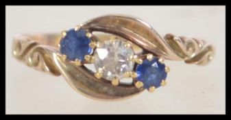 A 9ct gold Diamond and Sapphire ring having a central diamond surmounted by sapphires.