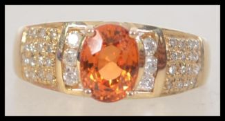 A 14ct yellow gold and citrine diamond ring, the large central oval cut citrine of approx 1.5cts.