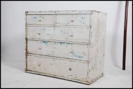 An early 20th century shabby chic painted pine chest of drawers having 2 short over 3 deep