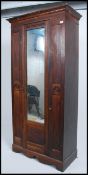 An Edwardian painted scrumble finish pine wardrobe having single mirror glass door with square