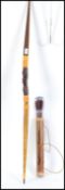 A tribal bow having carved head to centre together with arrows - quills in cylindrical holder.