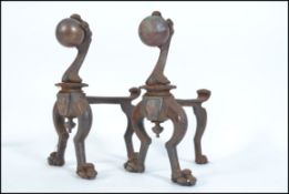 A pair of Victorian / early 20th century cast metal Arts & Crafts fire dogs having ball and claw