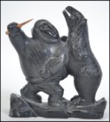 An unusual believed early 20th century Inuit carved stone diorama figure group of an eskimo
