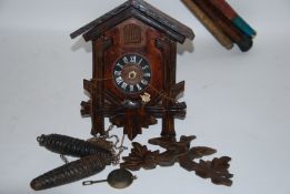 A 20th century Black forest style carved cuckoo wall hanging clock with vine decoration.