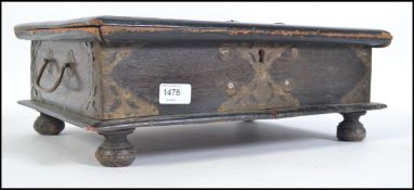 A oak and brass bound Bible box in the 17th Century style with hinged top raised on bun feet.