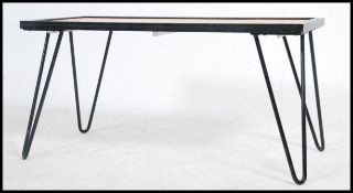 A contemporary retro cast metal hairpin leg coffee table having inset planked pine table top above.