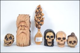A collection of 4 hand carved and painted wooden sculls of small form being well painted and