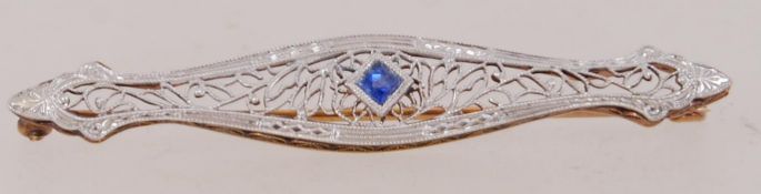 A boxed 14ct gold bar brooch with filigree decoration set with central blue sapphire with saftey