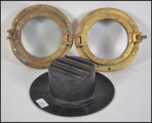 A pair of vintage 20th century bronze port holes together with a WW2 blackout car head light