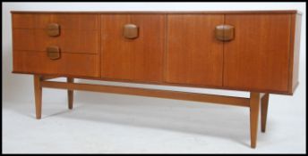 A 1970's Danish inspired retro teak wood sideboard having a bank of drawers with cupboards and fall