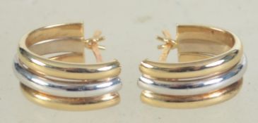 A pair of hallmarked 9ct gold two tone gold hoop earrings. Weight 2.1g.