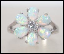 A ladies silver and opal flower head ring having pierced shoulder to the shank. Total weight 3.