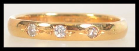 A hallmarked 22ct band ring set with three diamonds. Size R. Diamonds approx 15pts.