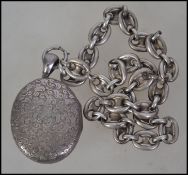 A Victorian silver hallmarked locket and chain having a chase decorated design and notation to the