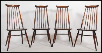 A set of 4 Ercol beech and elm Goldsmiths dining chairs with railed back rests over saddle seats