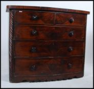 A Victorian mahogany bow front 2 over 3 chest of drawers being raised on pad supports with shaped