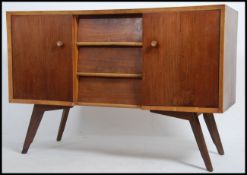 A 1950's mid century walnut sideboard dresser of low and wide form raised on tapering supports