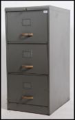 A vintage mid 20th century three drawer grey painted filing cabinet with brass style ribbed handles.