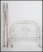A Victorian cast iron painted 3/4 double bed having arched head and footboards being complete with